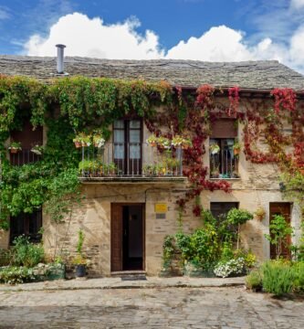 brown brick house with green plants on the side